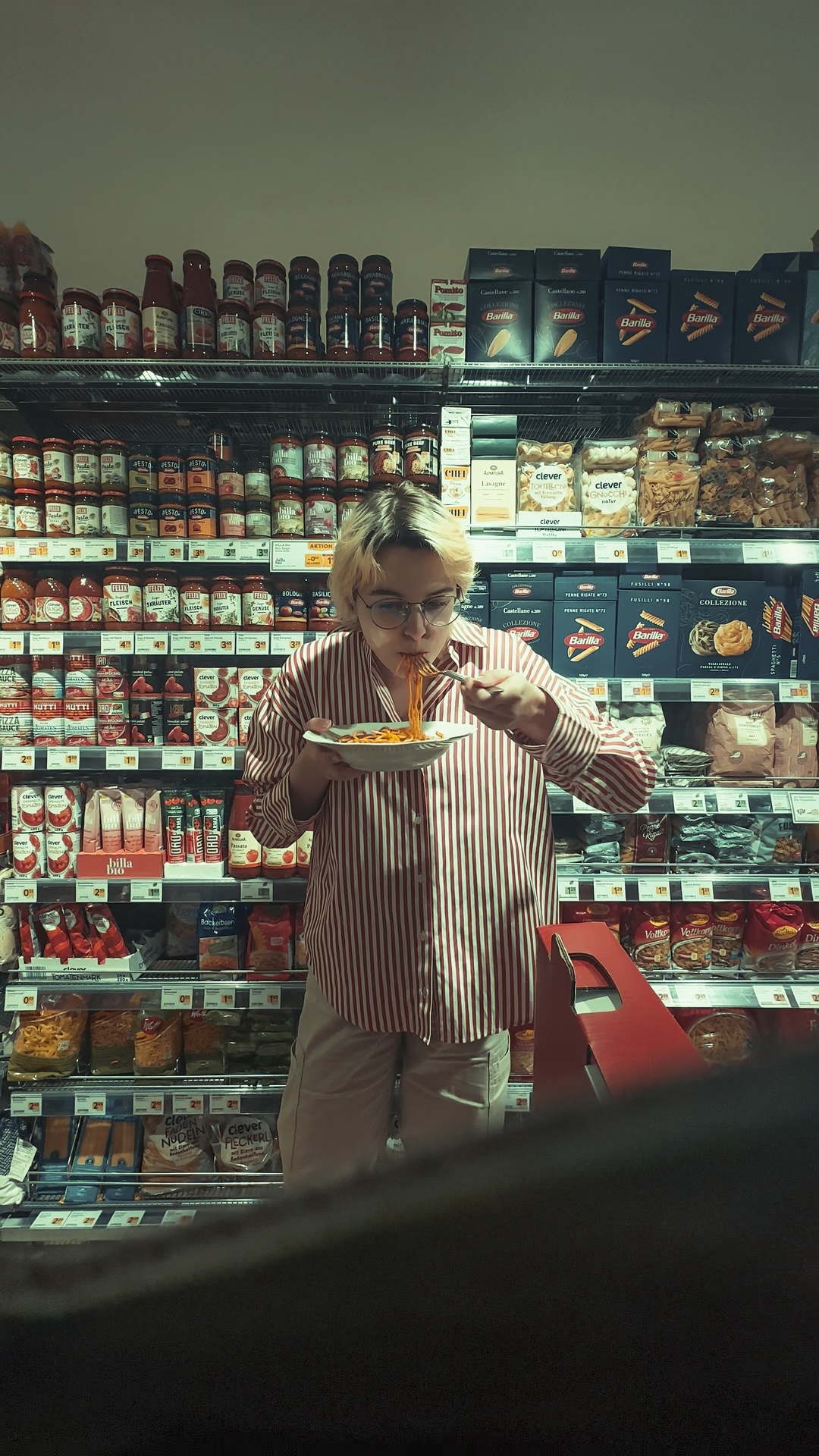 a girl eating spaghetti in a supermarket