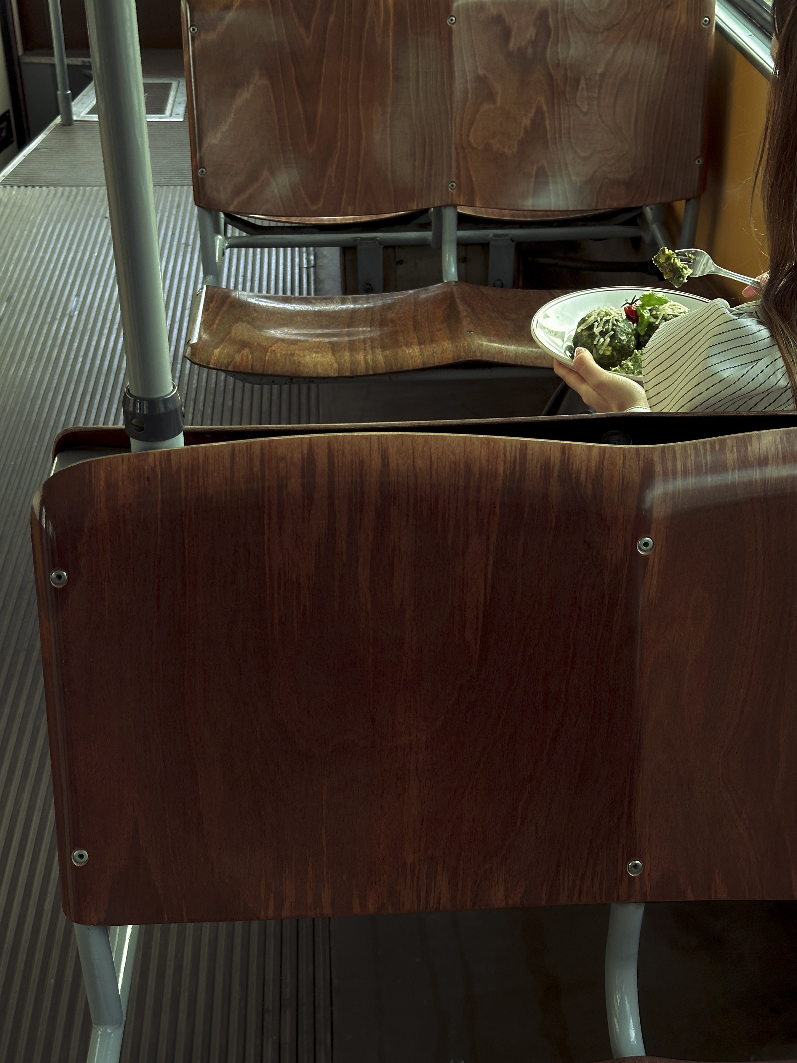 a girl eating Spinatknoedel in a tram