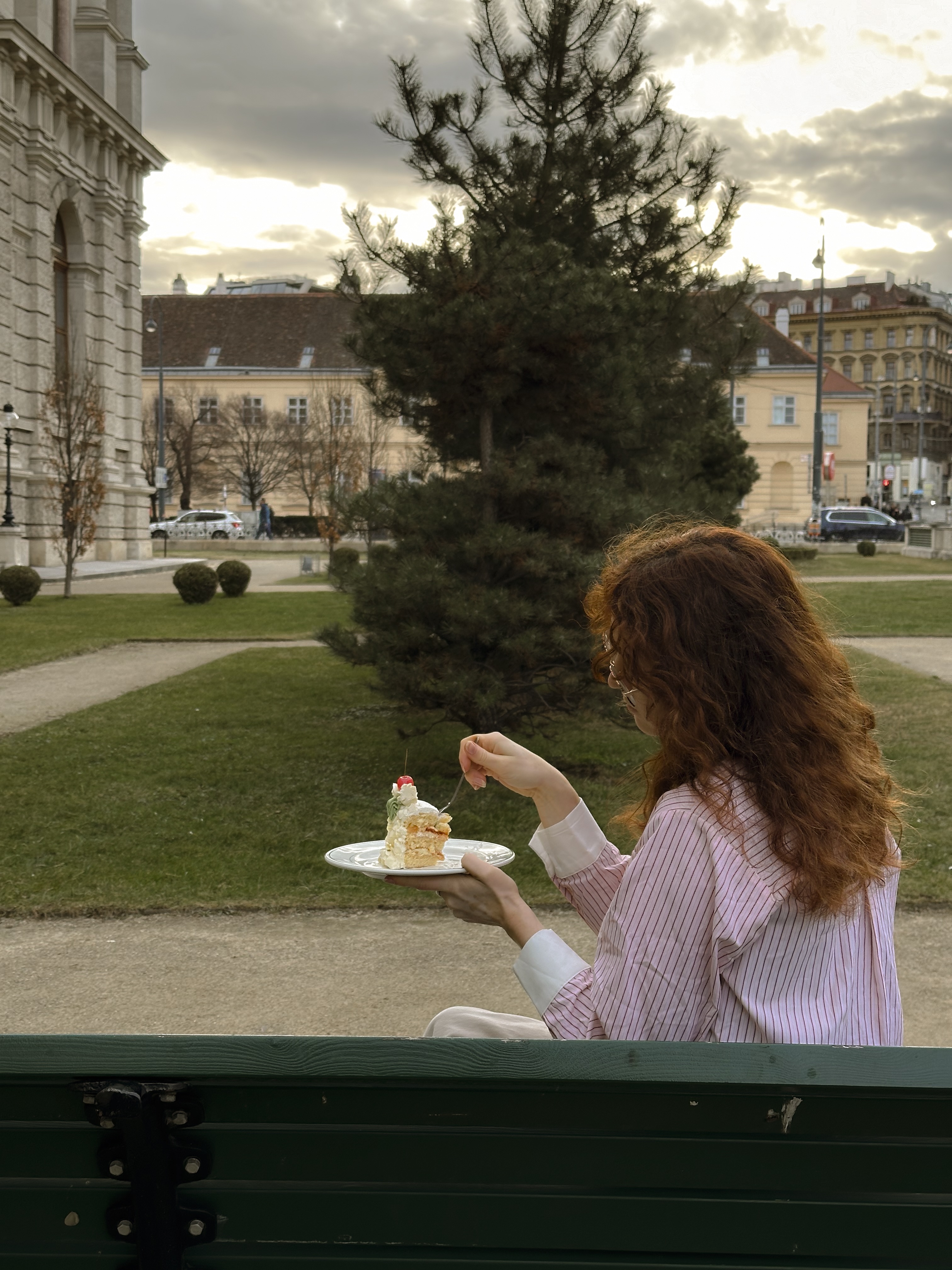 a girl eating cake in the city